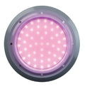 Round LED pool light with silver stainless steel bezel emitting pink-purple colour-changing glow, multi-point screw fixing, retro fit design